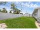 Spacious backyard with a white fence and lush green grass provides a serene setting at 1025 Capella Dr, Tavares, FL 32778