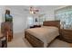Bedroom featuring a large bed, ceiling fan, dresser and neutral decor at 1025 Capella Dr, Tavares, FL 32778