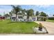 Well-maintained single-story home with a lush front lawn, palm trees, and a convenient carport at 1025 Capella Dr, Tavares, FL 32778