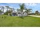 Single-story home with a large front yard, palm trees, and a well-manicured lawn at 1025 Capella Dr, Tavares, FL 32778