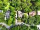 Aerial view of a property surrounded by a lush landscape with mature trees and well-maintained greenery at 1053 Cavern Dr, Apopka, FL 32712