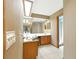 Bathroom with a long countertop, large mirror, and ample lighting at 1053 Cavern Dr, Apopka, FL 32712