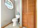 Bathroom with a toilet and a unique octagon window for lots of light, with a natural wood closet at 1053 Cavern Dr, Apopka, FL 32712