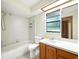Bathroom featuring a shower-tub combo, tile walls, large window, and a vanity with white countertops at 1053 Cavern Dr, Apopka, FL 32712