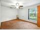 Bedroom featuring carpeted floor, ceiling fan, window with backyard view, and standard closet at 1053 Cavern Dr, Apopka, FL 32712