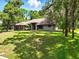 Charming single-story home with mature trees, a well-manicured lawn, and exterior shutters at 1053 Cavern Dr, Apopka, FL 32712