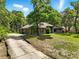 Single story home with a long concrete driveway and mature trees providing natural shade at 1053 Cavern Dr, Apopka, FL 32712