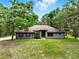 Charming single-story home with mature trees, a well-maintained lawn, and neutral colored exterior at 1053 Cavern Dr, Apopka, FL 32712
