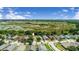 An aerial view of a neighborhood with lush greenery and a pond in the background at 1055 Bluegrass Dr, Groveland, FL 34736