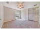 Spacious bedroom with neutral carpet and walls, ceiling fan and natural lighting at 1055 Bluegrass Dr, Groveland, FL 34736