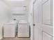 Laundry room with washer, dryer, and shelving for storage at 1055 Bluegrass Dr, Groveland, FL 34736