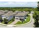 Aerial view of community homes with lush landscaping, serene streets, and glimpses of a nearby lake at 1131 Dora Parc Ln, Mount Dora, FL 32757