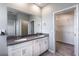 Double vanity bathroom with quartz countertops, white cabinetry, and walk-in closet at 1131 Dora Parc Ln, Mount Dora, FL 32757