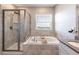 Bright bathroom featuring a soaking tub with tile surround and separate glass-enclosed shower at 1131 Dora Parc Ln, Mount Dora, FL 32757