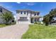 Charming two-story home with a well-manicured lawn and a paver driveway leading to a two-car garage at 1131 Dora Parc Ln, Mount Dora, FL 32757