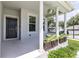Inviting front porch with columns, stylish planters, and a hanging plant creating a welcoming entrance at 1131 Dora Parc Ln, Mount Dora, FL 32757