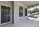 Cozy front porch with a swing seat, a gray front door, and ample natural light at 1131 Dora Parc Ln, Mount Dora, FL 32757
