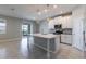 Open kitchen with island, pendant lights, white cabinets, and sliding glass doors to a balcony at 1131 Dora Parc Ln, Mount Dora, FL 32757