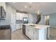 Stylish kitchen with island, pendant lighting, white cabinets, and stainless-steel appliances at 1131 Dora Parc Ln, Mount Dora, FL 32757