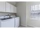 Well-equipped laundry room with modern washer and dryer, and storage cabinets at 1131 Dora Parc Ln, Mount Dora, FL 32757