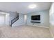 Inviting living room with a staircase, a wall-mounted TV, and neutral tile flooring at 1131 Dora Parc Ln, Mount Dora, FL 32757
