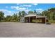 Exterior of barn, featuring a covered area and ample parking space, ideal for various outdoor activities at 14227 County Road 455, Clermont, FL 34711