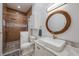 Nicely tiled bathroom with glass enclosed shower, white vanity, and wooden mirror at 14227 County Road 455, Clermont, FL 34711