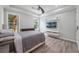 Modern bedroom with a ceiling fan, TV, and large windows showing the lush greenery outside at 14227 County Road 455, Clermont, FL 34711