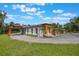 Exterior view of the home with a porte-cochere, gravel driveway, and lush green lawn at 14227 County Road 455, Clermont, FL 34711