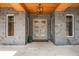Close-up of the front door featuring stone accents, a modern light fixture, and a welcoming entrance at 14227 County Road 455, Clermont, FL 34711