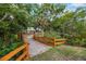 Scenic backyard landscape featuring a wooden bridge leading to lush greenery and a tranquil pond at 14227 County Road 455, Clermont, FL 34711