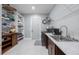 Well-organized laundry room featuring a sink, washer, dryer, and ample shelving for storage at 14227 County Road 455, Clermont, FL 34711