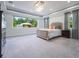 Bright main bedroom with large windows, neutral carpet, and a decorative chandelier at 14227 County Road 455, Clermont, FL 34711