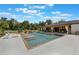 Backyard oasis with a pool, waterfalls, lush landscaping, and an outdoor kitchen area at 14227 County Road 455, Clermont, FL 34711