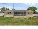 Home's backyard with screened in porch and white fence at 1491 Providence Blvd, Deltona, FL 32725