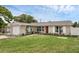 Charming single-story home featuring a green lawn, garden area, and a single car garage at 1491 Providence Blvd, Deltona, FL 32725