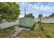 Green utility shed on wooden platform is in the backyard at 1491 Providence Blvd, Deltona, FL 32725