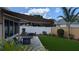 Outdoor seating area with a fire pit, artificial turf and mature landscaping, perfect for outdoor entertaining at 1496 Lime Grove Ln, The Villages, FL 32162