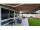 Relaxing backyard featuring a retractable awning, patio, artificial grass and nice landscaping at 1496 Lime Grove Ln, The Villages, FL 32162