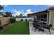 Backyard with artificial turf, outdoor seating area, and well-maintained landscaping at 1496 Lime Grove Ln, The Villages, FL 32162