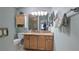 Bathroom vanity with granite countertop, wooden cabinets, and decorative wall cabinet above the toilet at 1496 Lime Grove Ln, The Villages, FL 32162