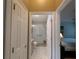Hallway view of a bathroom with a glass shower and tile flooring at 1496 Lime Grove Ln, The Villages, FL 32162