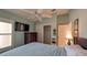 Bedroom with light green walls, ceiling fan, closet, and television at 1496 Lime Grove Ln, The Villages, FL 32162