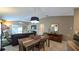 Open-concept living and dining area with a wooden table and a modern light fixture at 1496 Lime Grove Ln, The Villages, FL 32162