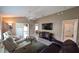Spacious living room with comfortable seating, ceiling fan, and access to the bathroom at 1496 Lime Grove Ln, The Villages, FL 32162
