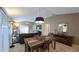 Open-concept living and dining room with modern lighting and a leather sofa at 1496 Lime Grove Ln, The Villages, FL 32162