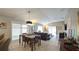 Open-concept living and dining area with a wooden table and sliding glass doors at 1496 Lime Grove Ln, The Villages, FL 32162