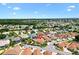 Aerial view of a lovely home nestled in a well-maintained community with lush landscaping and vibrant greenery at 1509 Trenton Ln, The Villages, FL 32162