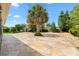 Landscaped backyard features a stone patio, mature trees, and provides an ideal space for outdoor entertaining at 1509 Trenton Ln, The Villages, FL 32162