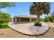 The backyard is designed with a decorative stone patio and carefully curated landscaping for privacy at 1509 Trenton Ln, The Villages, FL 32162